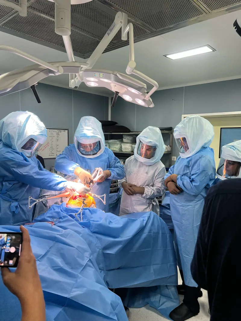 Operating theatre team around a patient during a robotic knee procedure